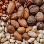 Pistazien, Walnüsse, Haselnüsse, Erdnüsse und Mandeln auf einem Haufen als Symbol für Schalenfrüchte